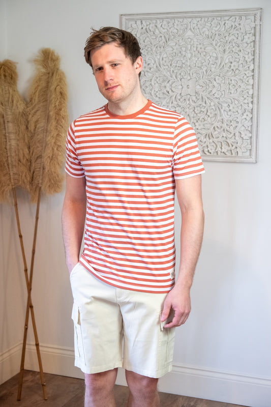 Lifestyle photograph of male model wearing a red stripe t-shirt and ecru cargo shorts