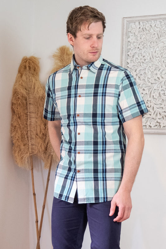 Male model wearing a short sleeved check shirt and blue trousers
